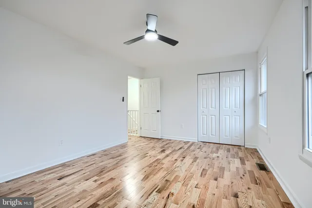 a view of empty room with wooden floor