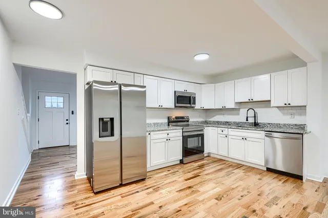 a kitchen with granite countertop stainless steel appliances a sink and counter space