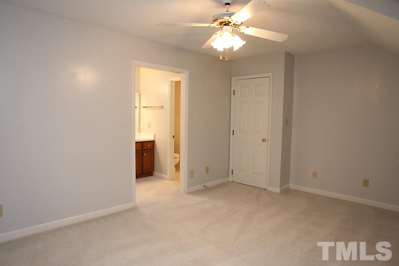 7811 Coach House Lane Raleigh, NC 27615 - Photo 14 of 19 an empty room with a ceiling fan and a window