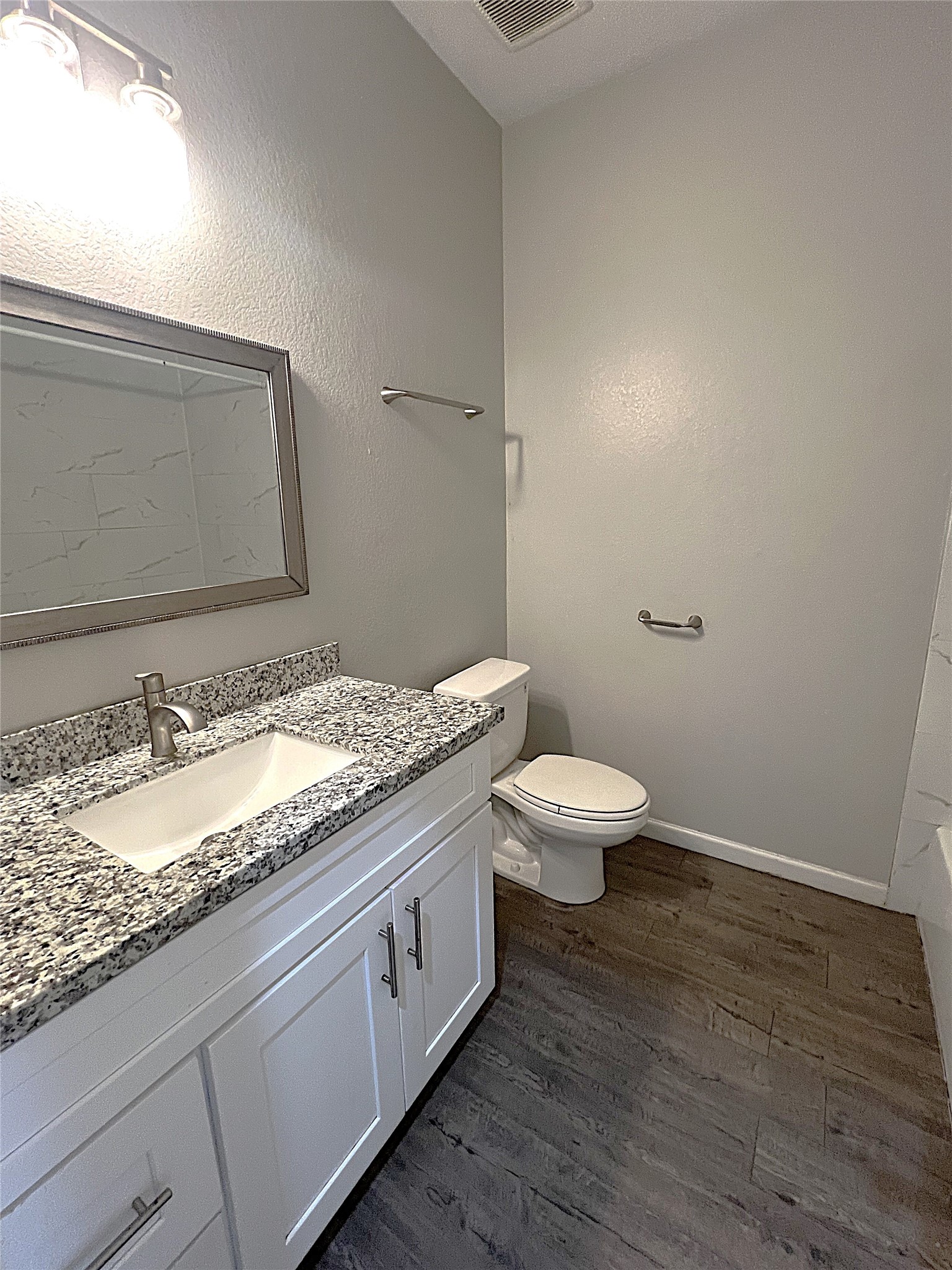 5779 Belarbor Street, Unit A Houston, TX 77033 - Photo 11 of 27 a bathroom with a granite countertop toilet and a sink
