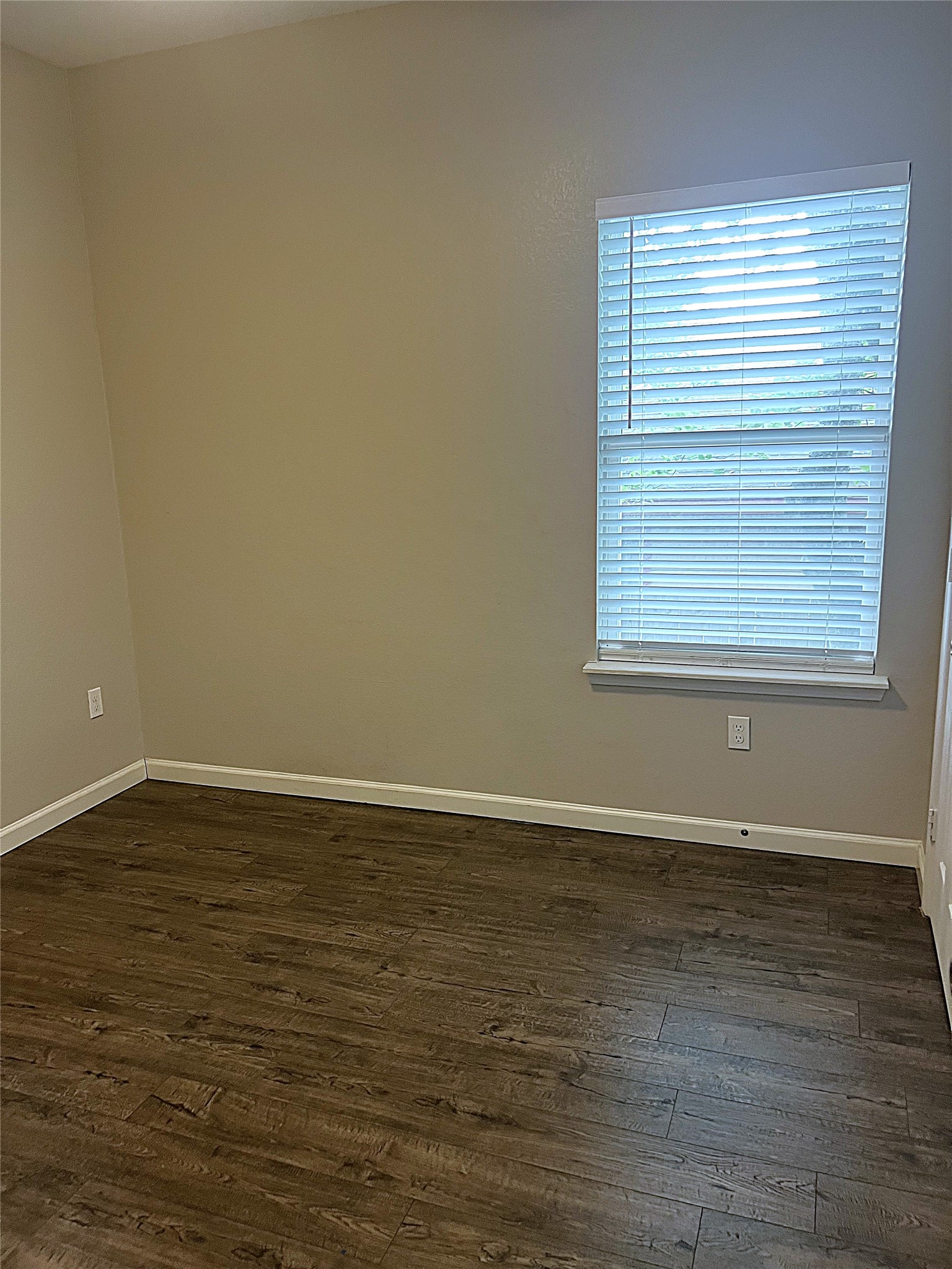 5779 Belarbor Street, Unit A Houston, TX 77033 - Photo 13 of 27 a view of an empty room with wooden floor and a window