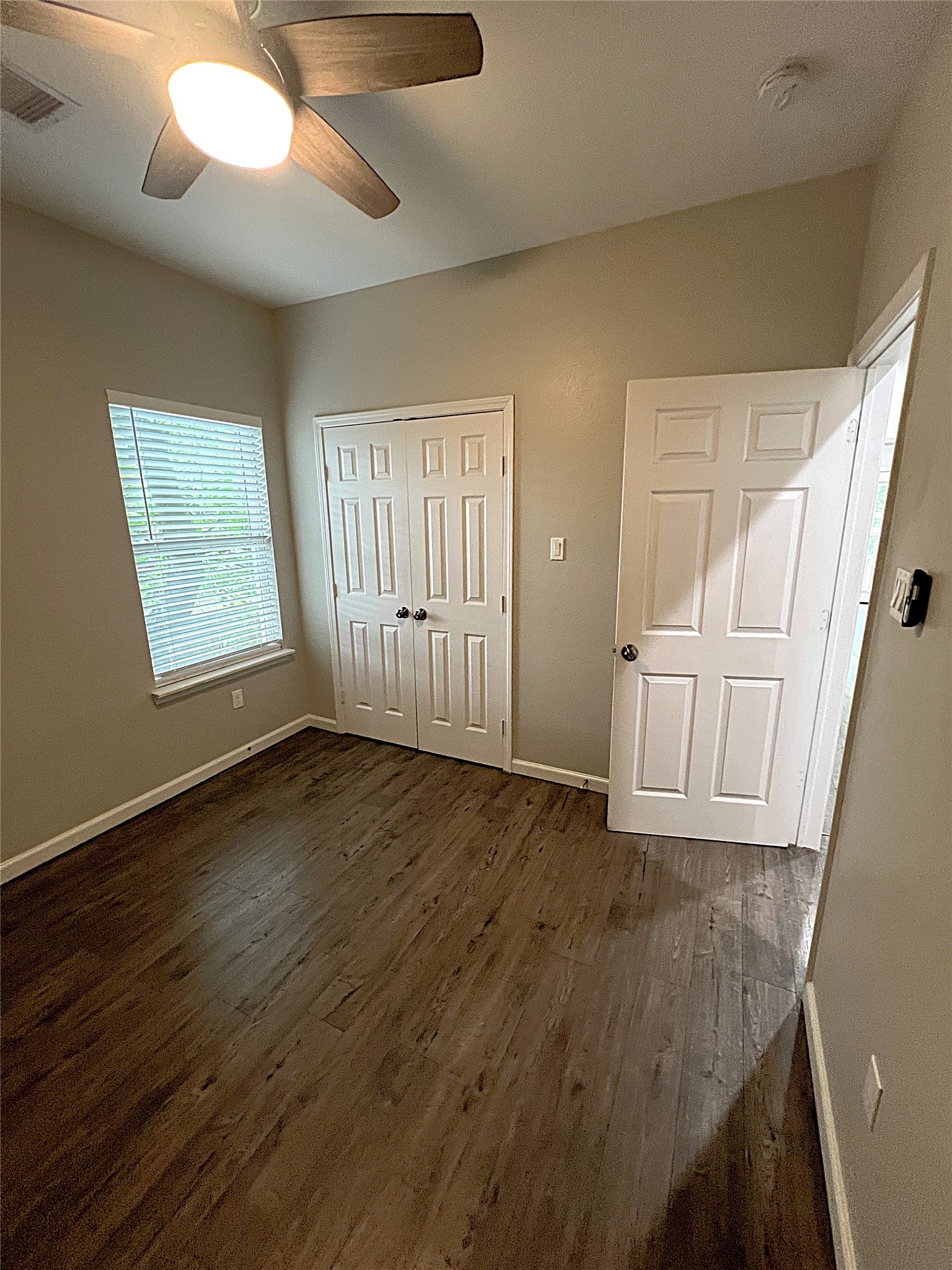 5779 Belarbor Street, Unit A Houston, TX 77033 - Photo 14 of 27 a view of an empty room with wooden floor and a window