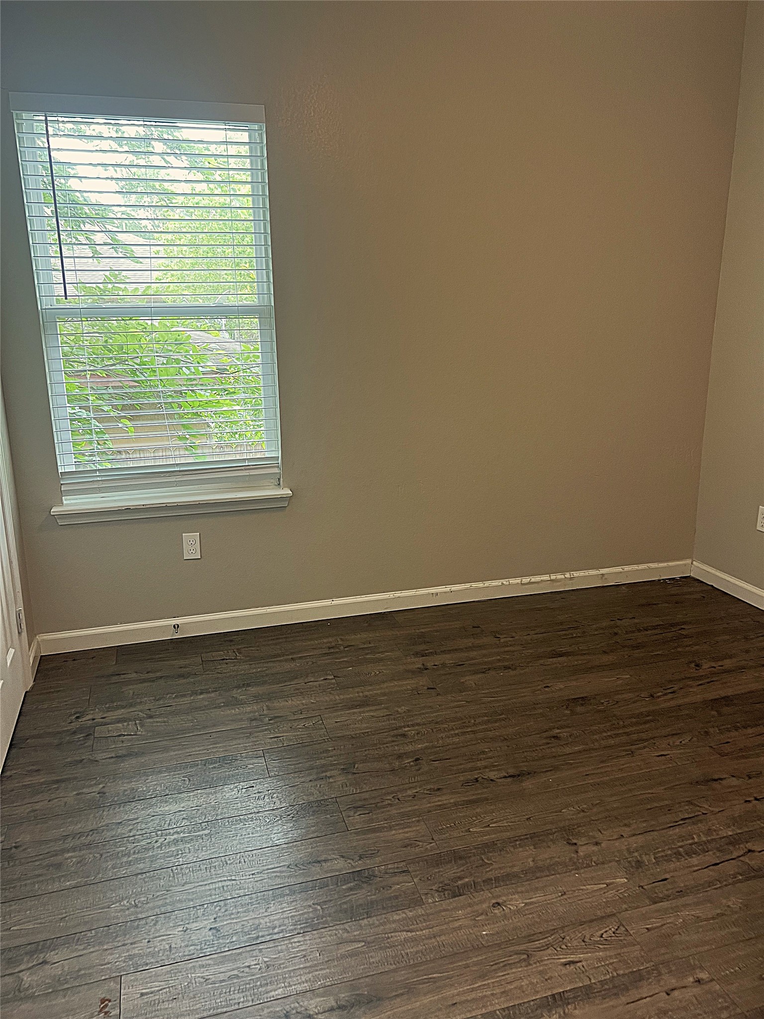 5779 Belarbor Street, Unit A Houston, TX 77033 - Photo 16 of 27 a view of an empty room with wooden floor and a window