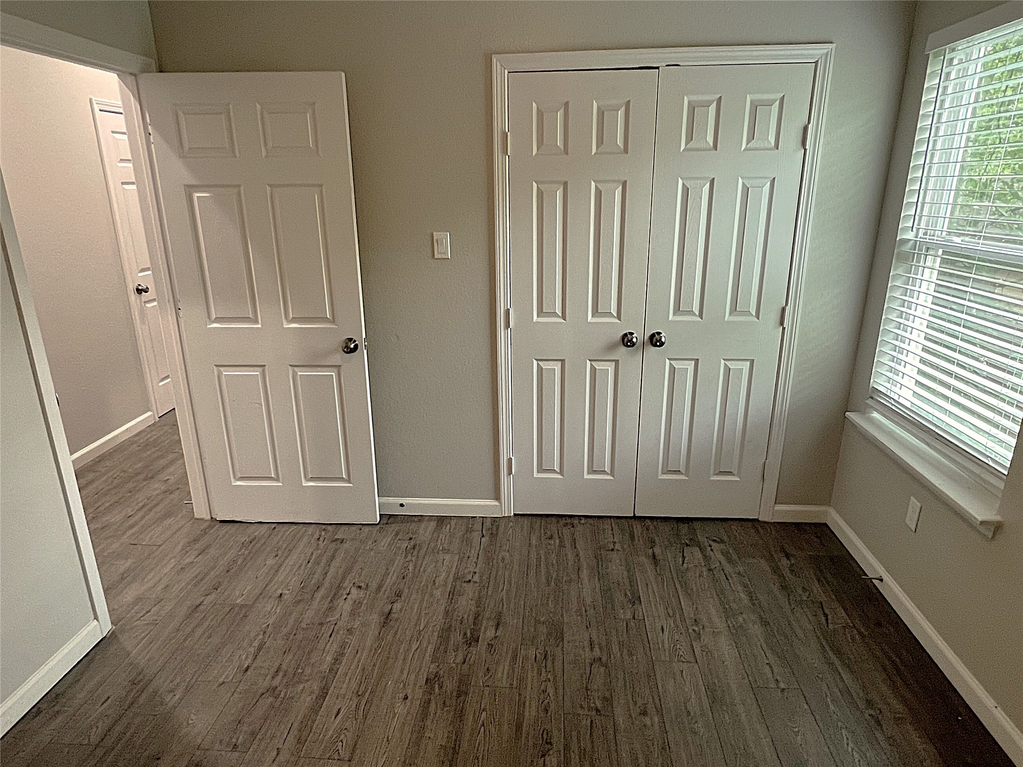 5779 Belarbor Street, Unit A Houston, TX 77033 - Photo 17 of 27 an empty room with wooden floor and windows