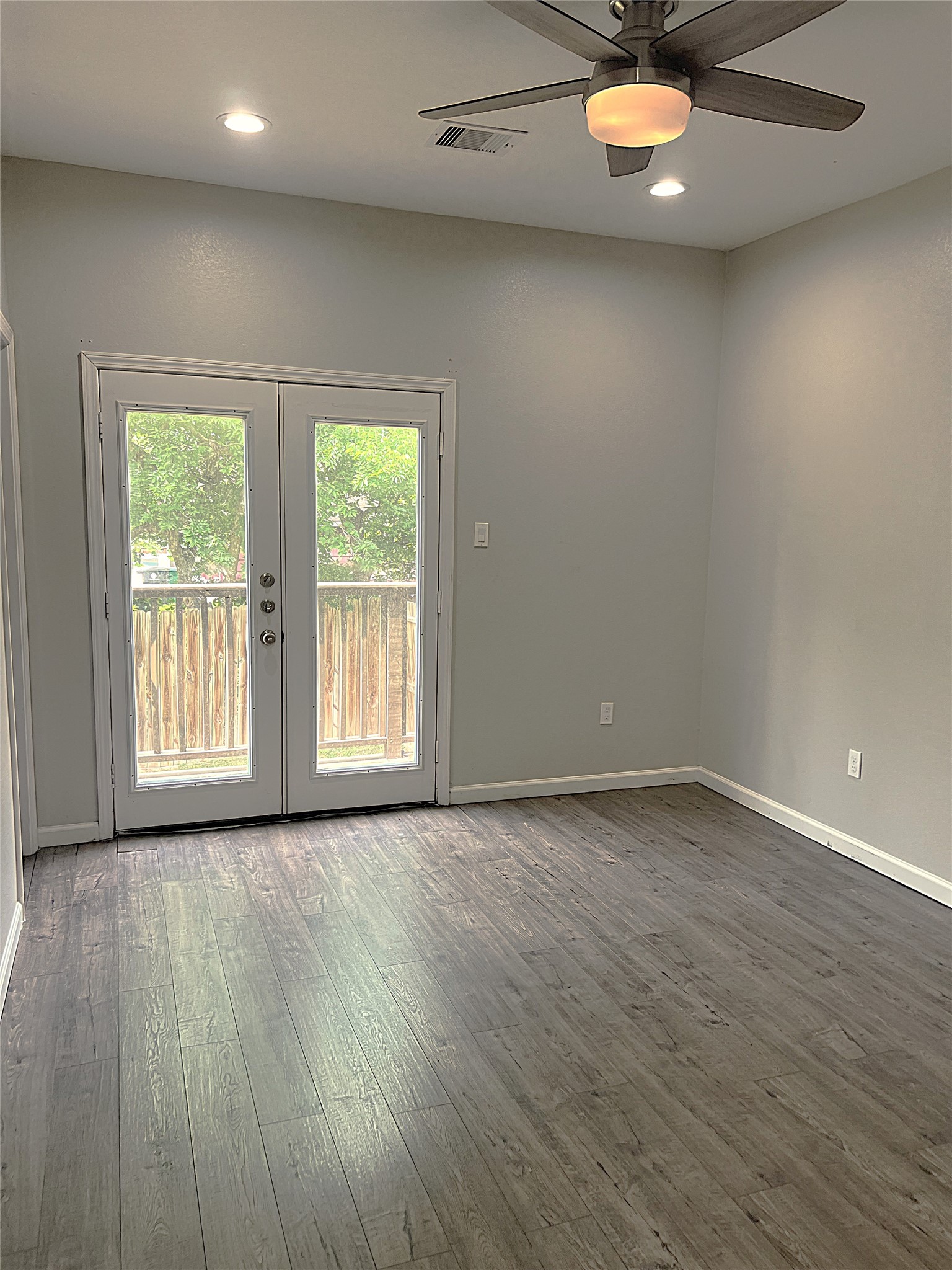 5779 Belarbor Street, Unit A Houston, TX 77033 - Photo 19 of 27 an empty room with wooden floor and windows