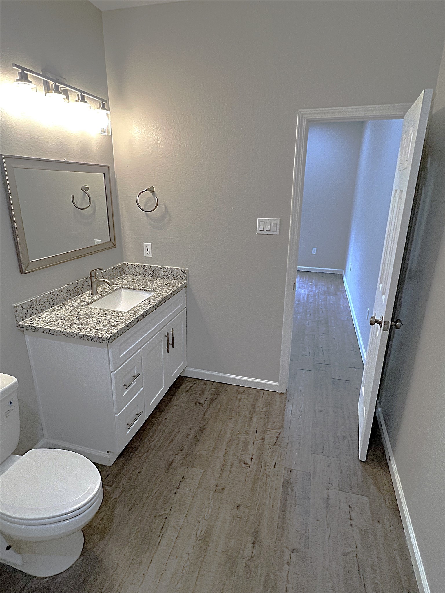 5779 Belarbor Street, Unit A Houston, TX 77033 - Photo 24 of 27 a bathroom with a granite countertop toilet sink and mirror