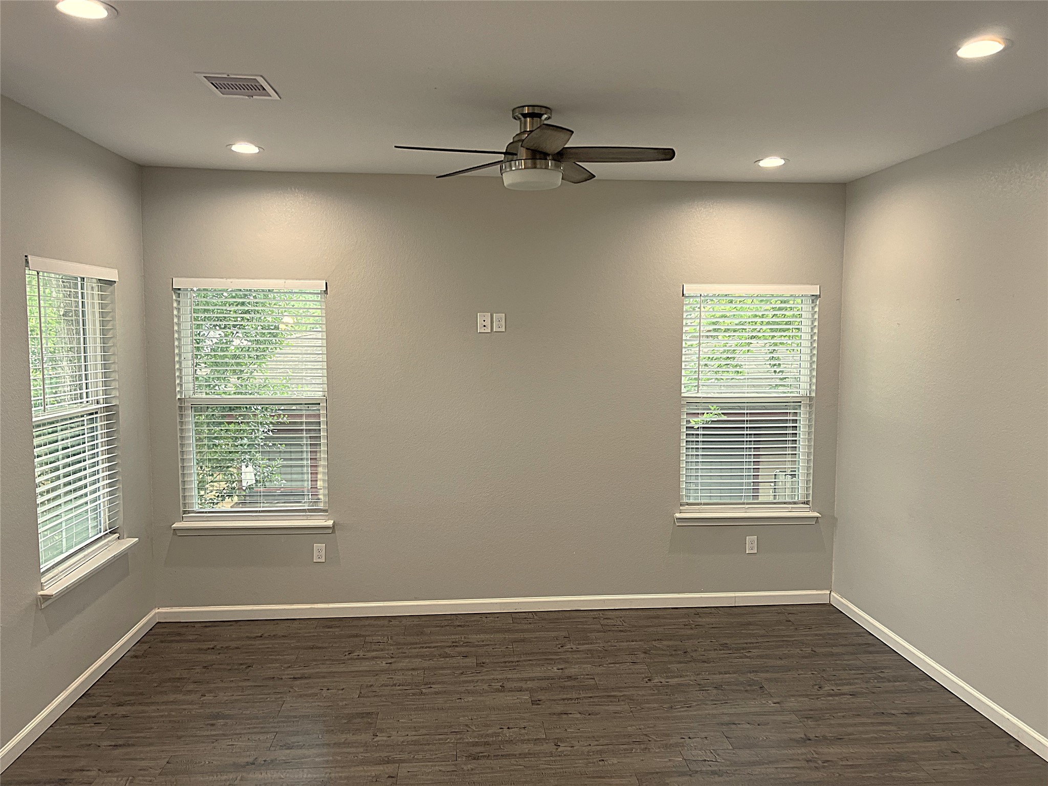 5779 Belarbor Street, Unit A Houston, TX 77033 - Photo 5 of 27 a view of an empty room with a window and wooden floor
