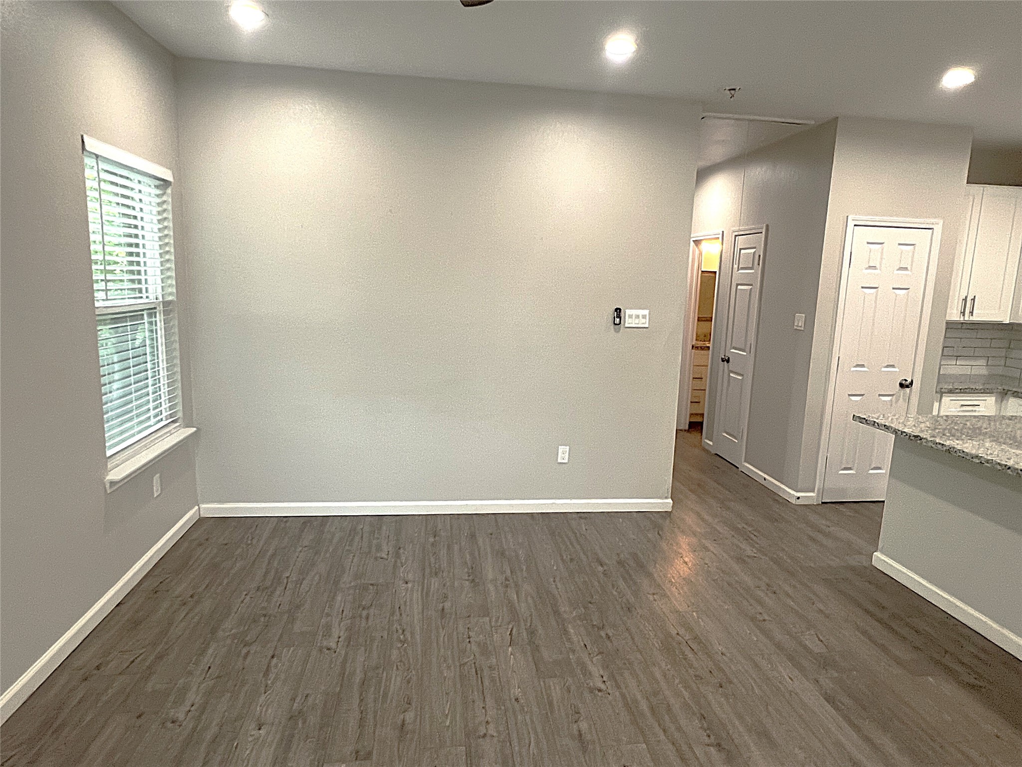 5779 Belarbor Street, Unit A Houston, TX 77033 - Photo 8 of 27 an empty room with wooden floor and windows