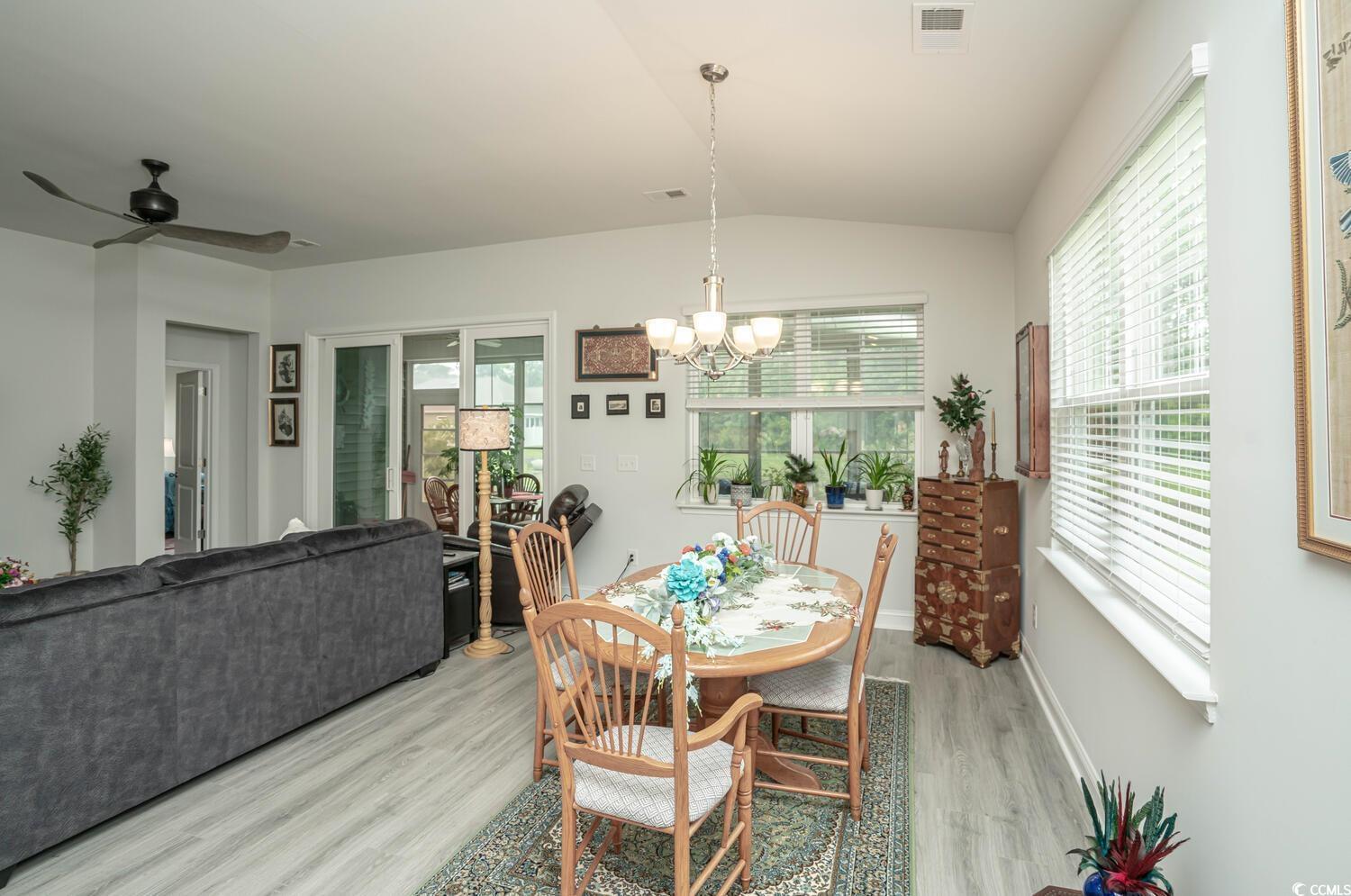 251 Juniata Loop Little River, SC 29566 - Photo 25 of 39 Dining room featuring light wood-style flooring, a chandelier, lofted ceiling, ceiling fan, and baseboards