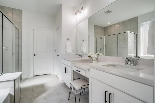 a bathroom with a sink double vanity granite tub shower and a mirror