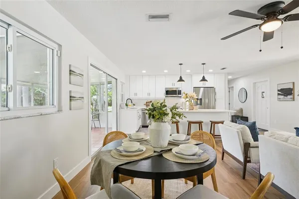 a kitchen with a table chairs refrigerator and cabinets