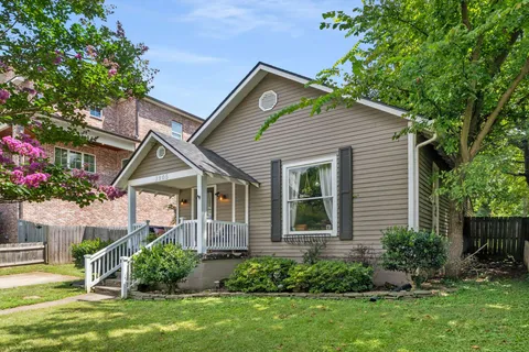 a front view of a house with a yard and potted plants