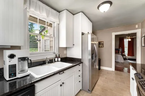 a kitchen with stainless steel appliances granite countertop a sink and a refrigerator