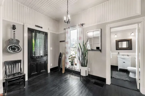 a view of a hallway with wooden floor and windows