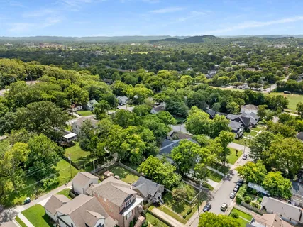an aerial view of residential houses with outdoor space and trees