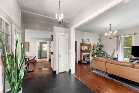 a living room with furniture a chandelier and a bookshelf