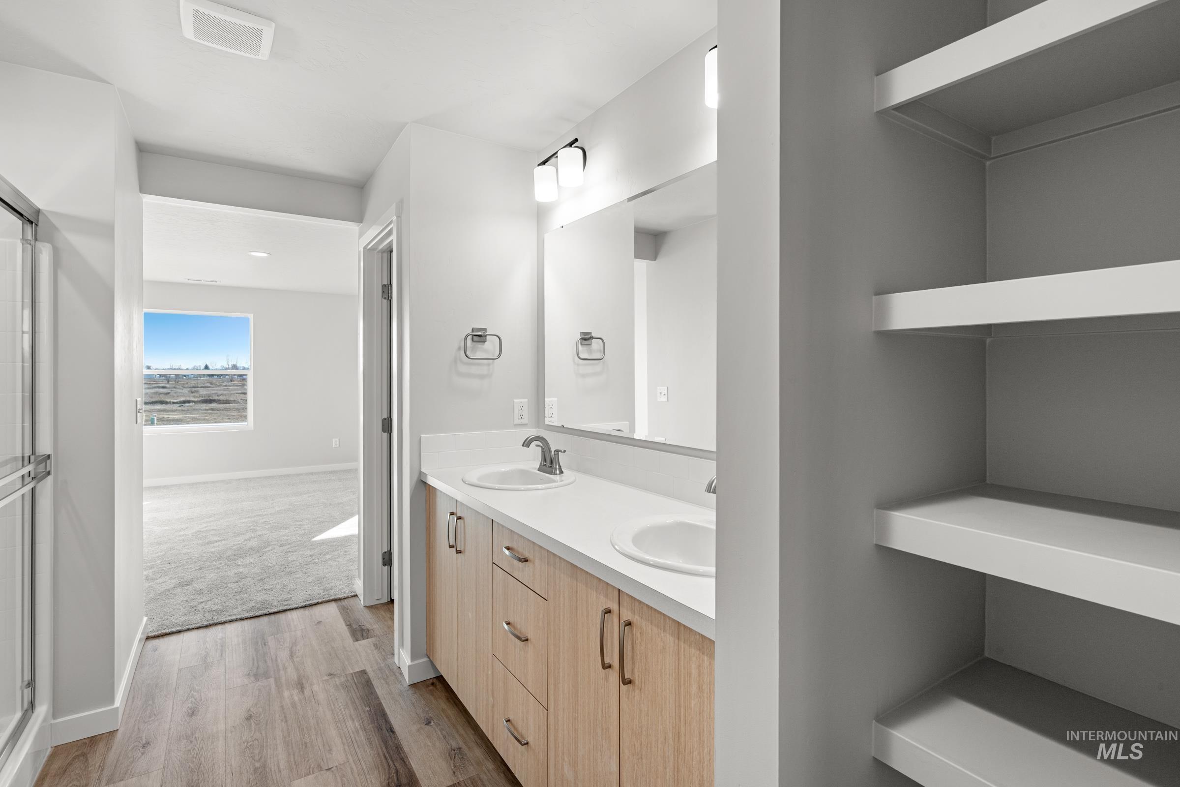 1647 Dyer Street Middleton, ID 83644 - Photo 23 of 25 Bathroom with double vanity, light wood-style flooring, and a shower stall