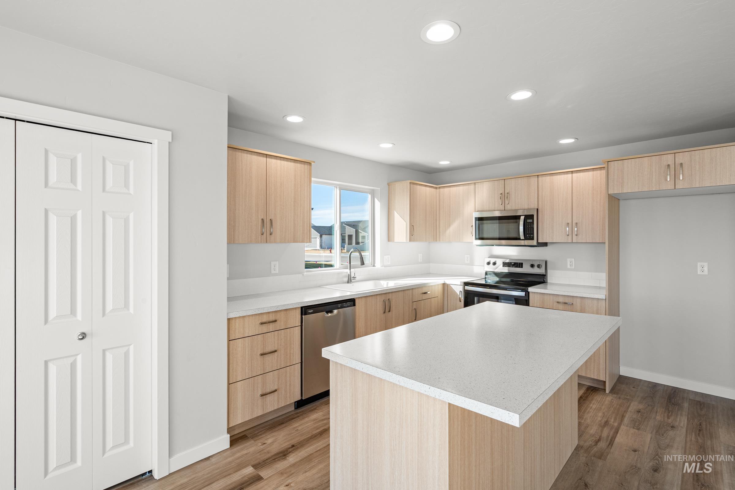 1647 Dyer Street Middleton, ID 83644 - Photo 4 of 25 Kitchen with light wood finish cabinetry, light countertops, stainless steel appliances, light wood-type flooring, and recessed lighting