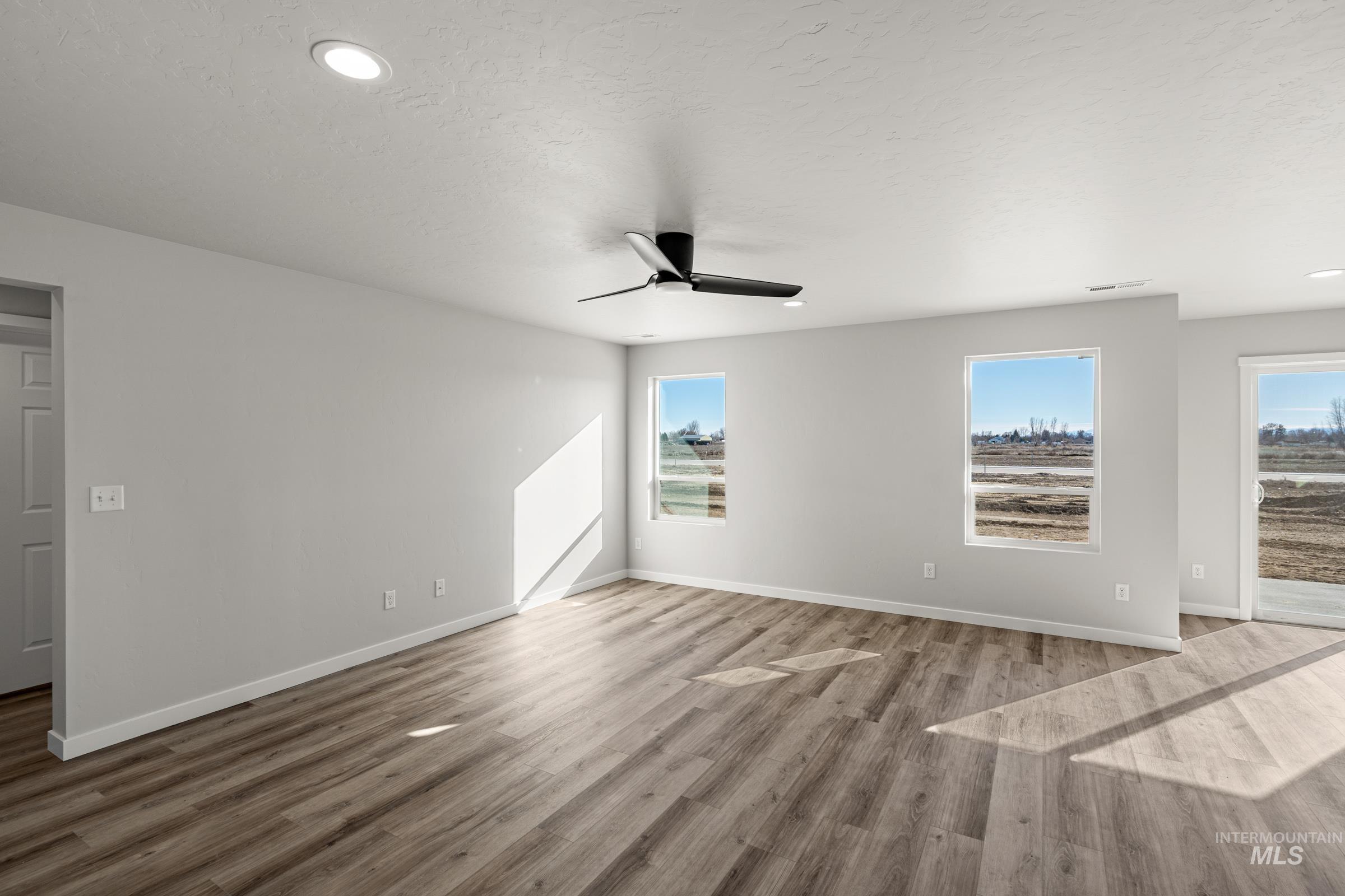 1647 Dyer Street Middleton, ID 83644 - Photo 8 of 25 Unfurnished room with ceiling fan, light wood-style floors, recessed lighting, and a textured ceiling