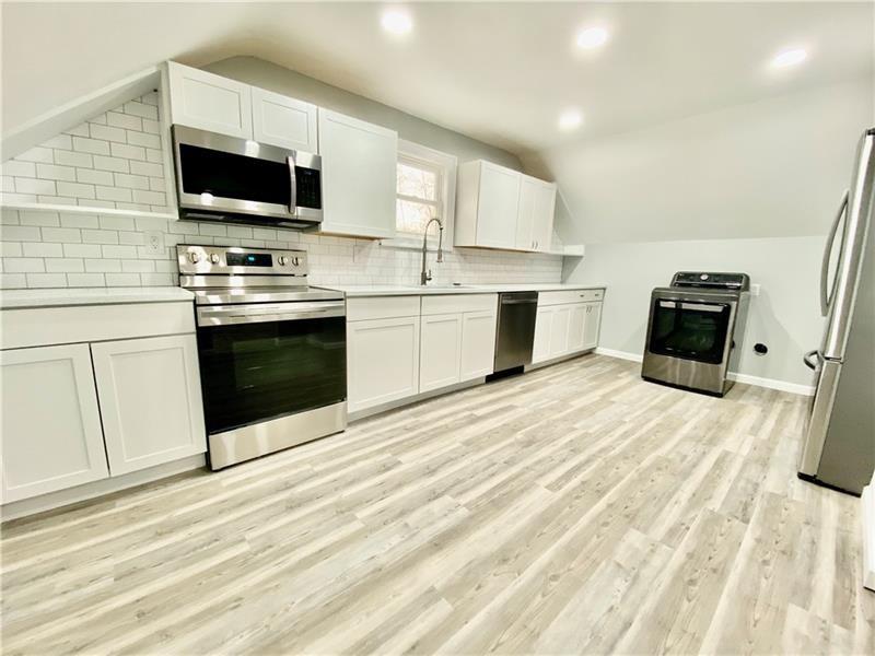 6630 Library Road South Park, PA 15129 - Photo 12 of 21 a kitchen with stainless steel appliances a stove top oven a sink a microwave and a refrigerator