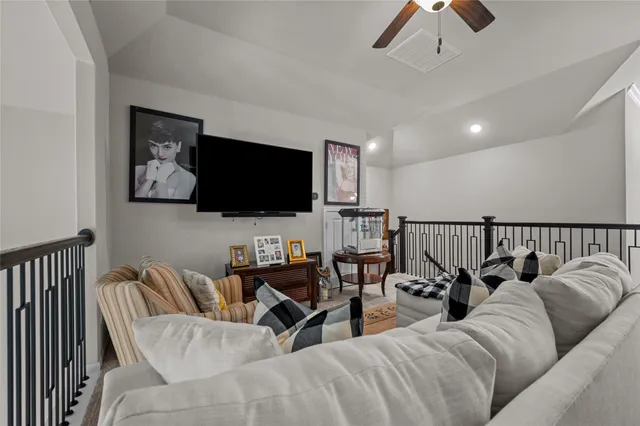 a living room with furniture kitchen view and a flat screen tv
