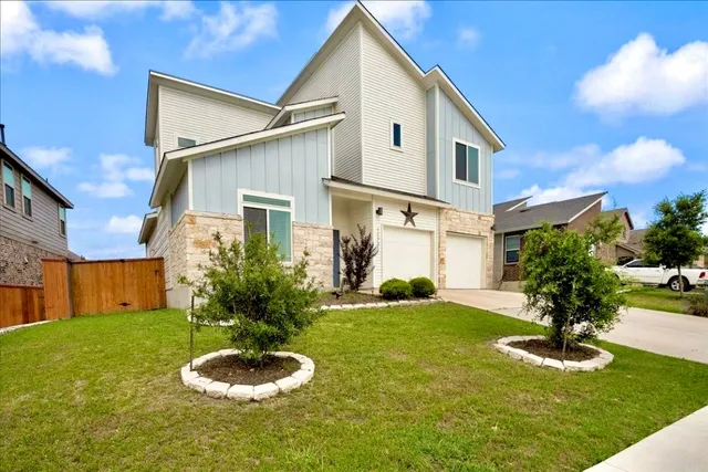 a front view of a house with a yard and garage