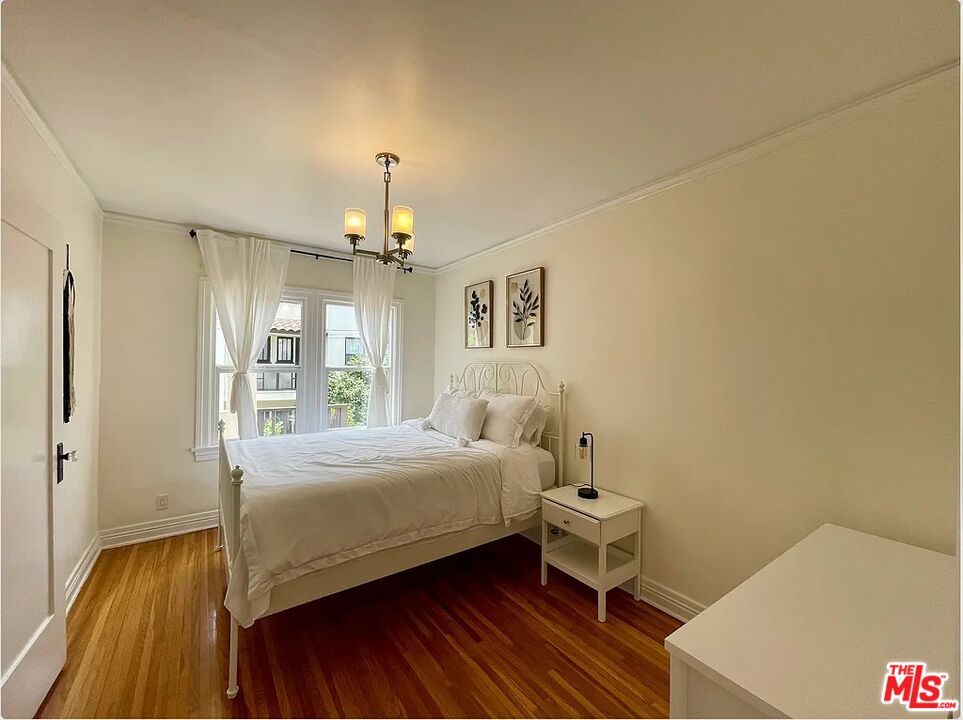 837 5th Street, Unit 839B Santa Monica, CA 90403 - Photo 3 of 23 a bedroom with a bed and a chandelier