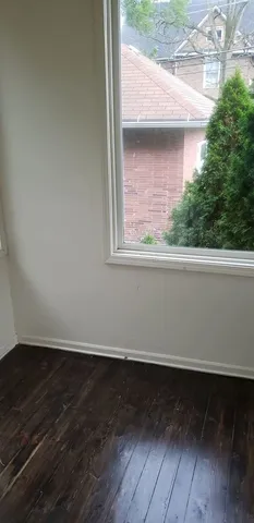 a view of a small space with wooden floor and a window