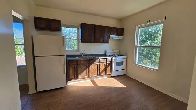 a kitchen with stainless steel appliances granite countertop a refrigerator a sink a stove a microwave a counter space and cabinets