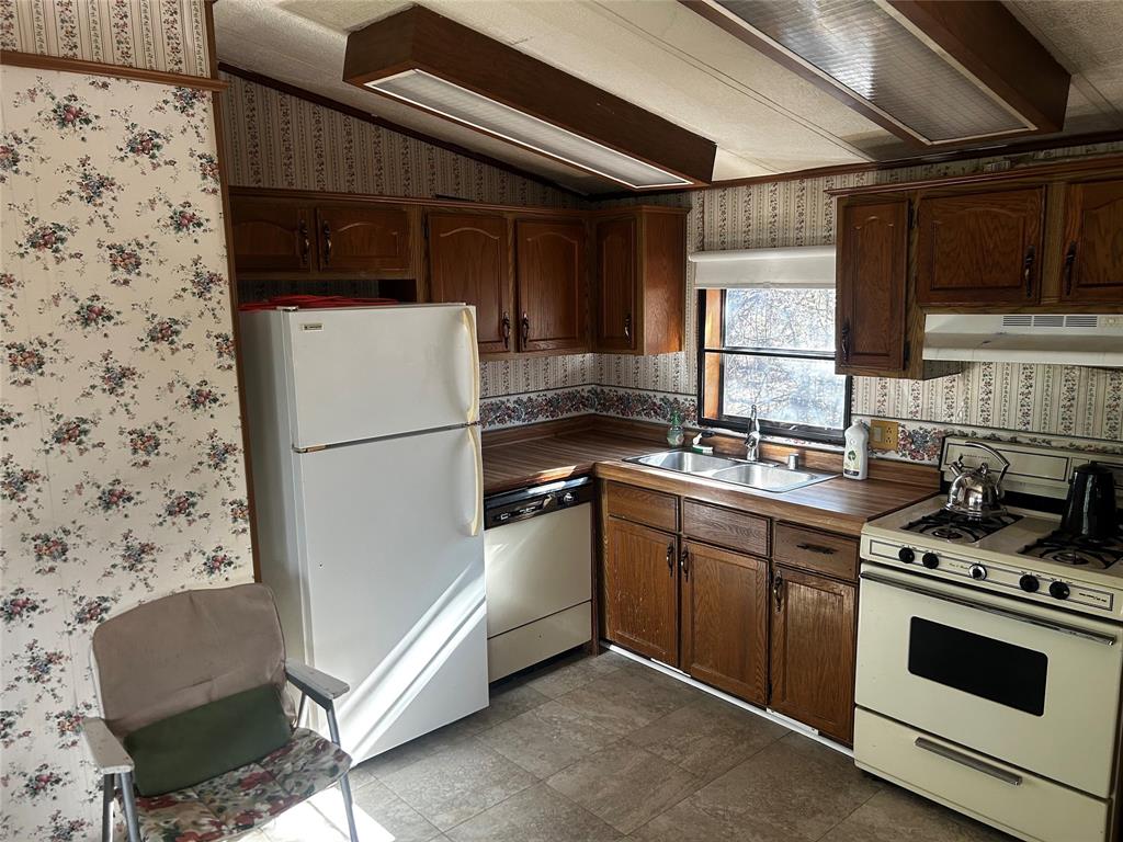 194 Lakeview Court Sunset, TX 76270 - Photo 16 of 19 a kitchen with a refrigerator and a sink
