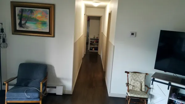 a view of a hallway with workspace and wooden floor