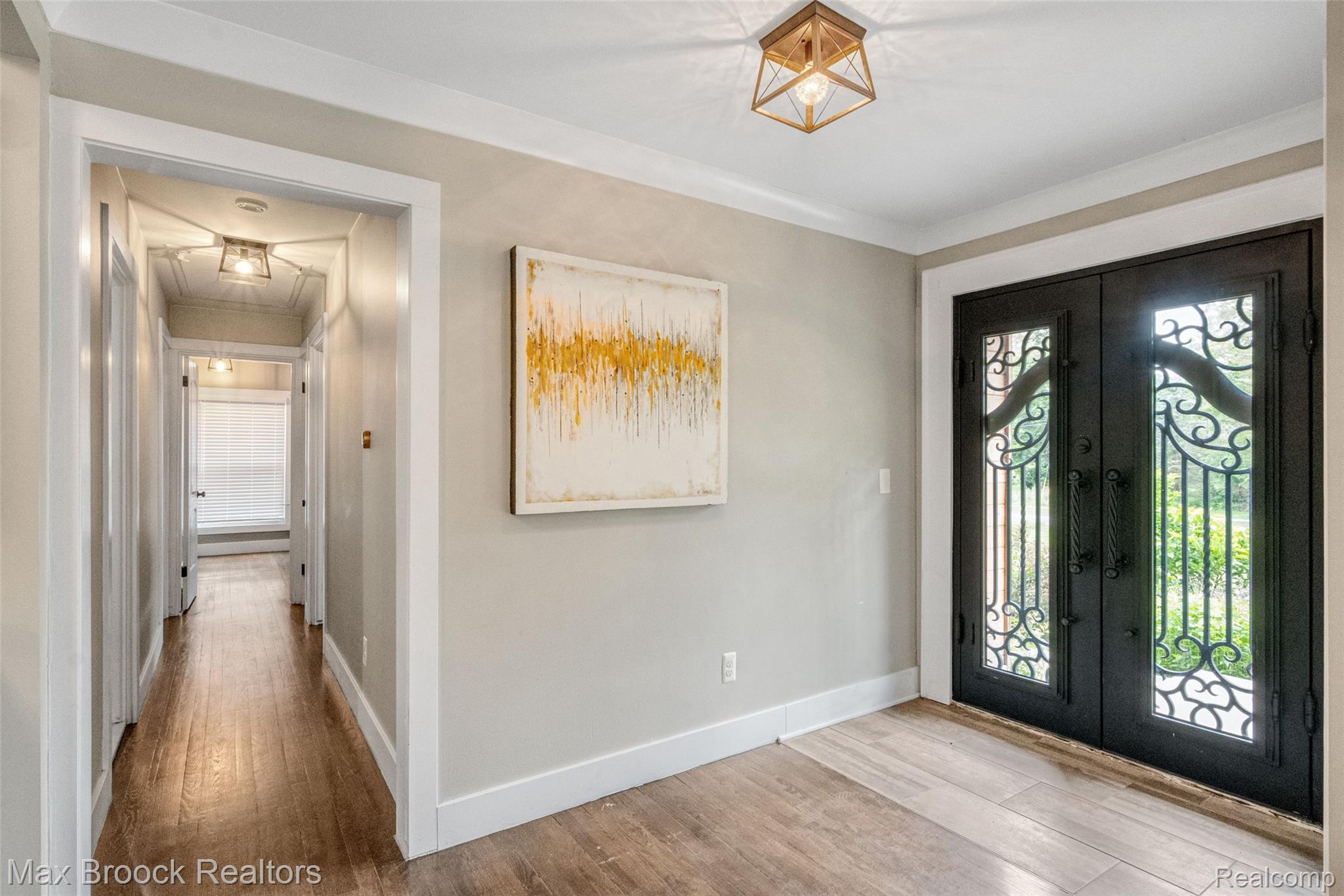 2905 Lahser Road Bloomfield Hills, MI 48304 - Photo 3 of 28 Elegant double entry doors with decorative ironwork, wood-finish flooring, crown molding, and a modern flush-mount light fixture