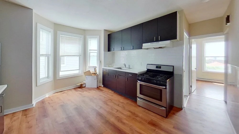 121 George Street, Unit 2 Boston, MA 02119 - Photo 2 of 8 a kitchen with a stove a sink and a refrigerator