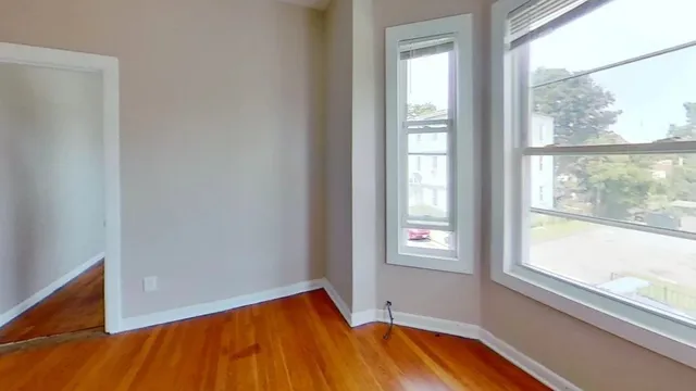 a view of a room with wooden floor and a window