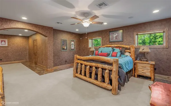 a white bed sitting in a room next to a window