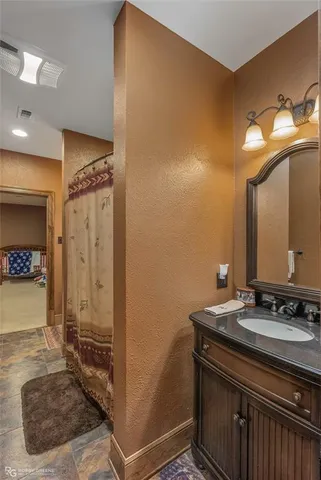 a bathroom with a granite countertop sink a mirror and a shower