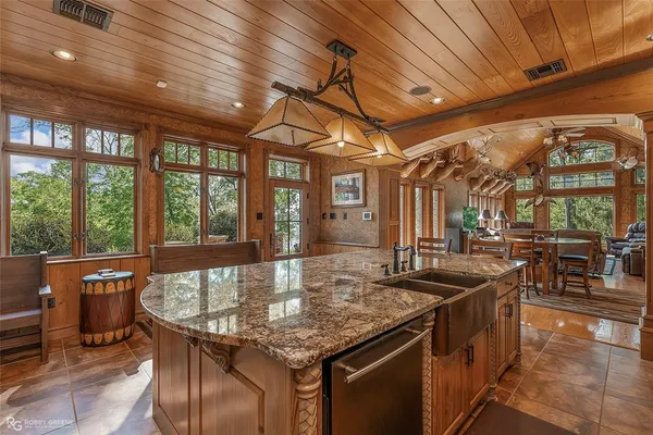 a kitchen with stainless steel appliances granite countertop a sink and wooden cabinets