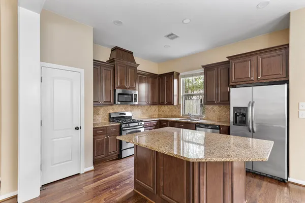 a kitchen with stainless steel appliances granite countertop a sink stove and refrigerator