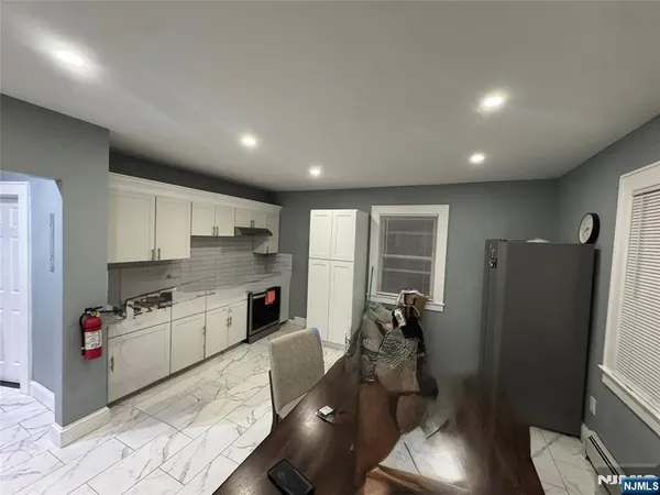 a kitchen with refrigerator a sink and wooden floor