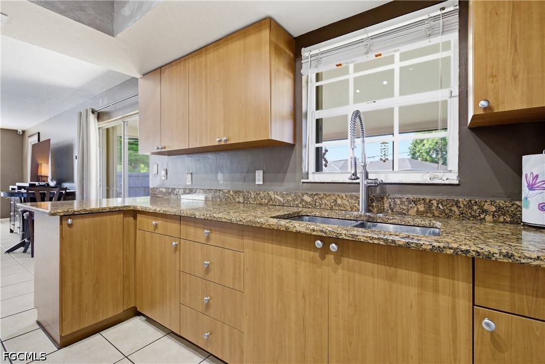 4960 20th Place Southwest Naples, FL 34116 - Photo 12 of 33 a kitchen with stainless steel appliances granite countertop a sink a stove and a microwave