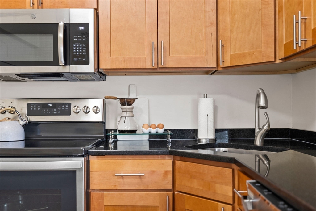 33 Clinton Street Framingham, MA 01702 - Photo 15 of 26 a kitchen with stainless steel appliances granite countertop a sink stove and cabinets