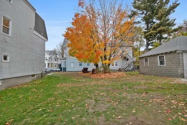 a view of a yard with a house and a large tree