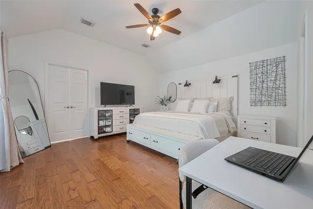 a spacious bedroom with a bed and a chandelier