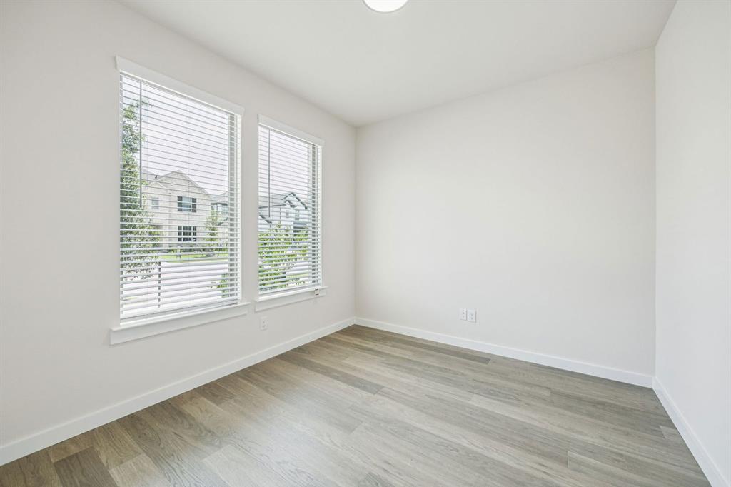 483 Sierra Ridge Lavon, TX 75166 - Photo 19 of 29 a view of an empty room with wooden floor and a window