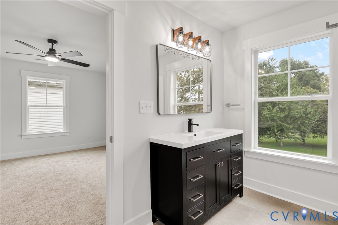 1619 12th Street Victoria, VA 23974 - Photo 29 of 30 a bathroom with a toilet a sink a window and mirror
