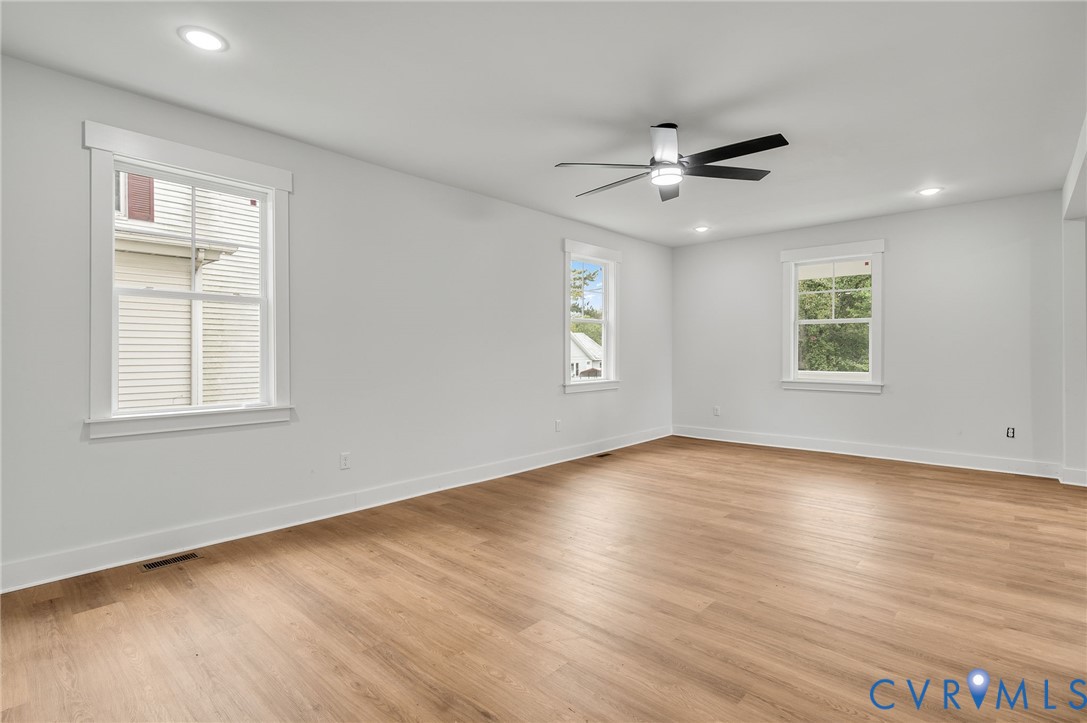 1619 12th Street Victoria, VA 23974 - Photo 10 of 30 an empty room with wooden floor ceiling fan and windows
