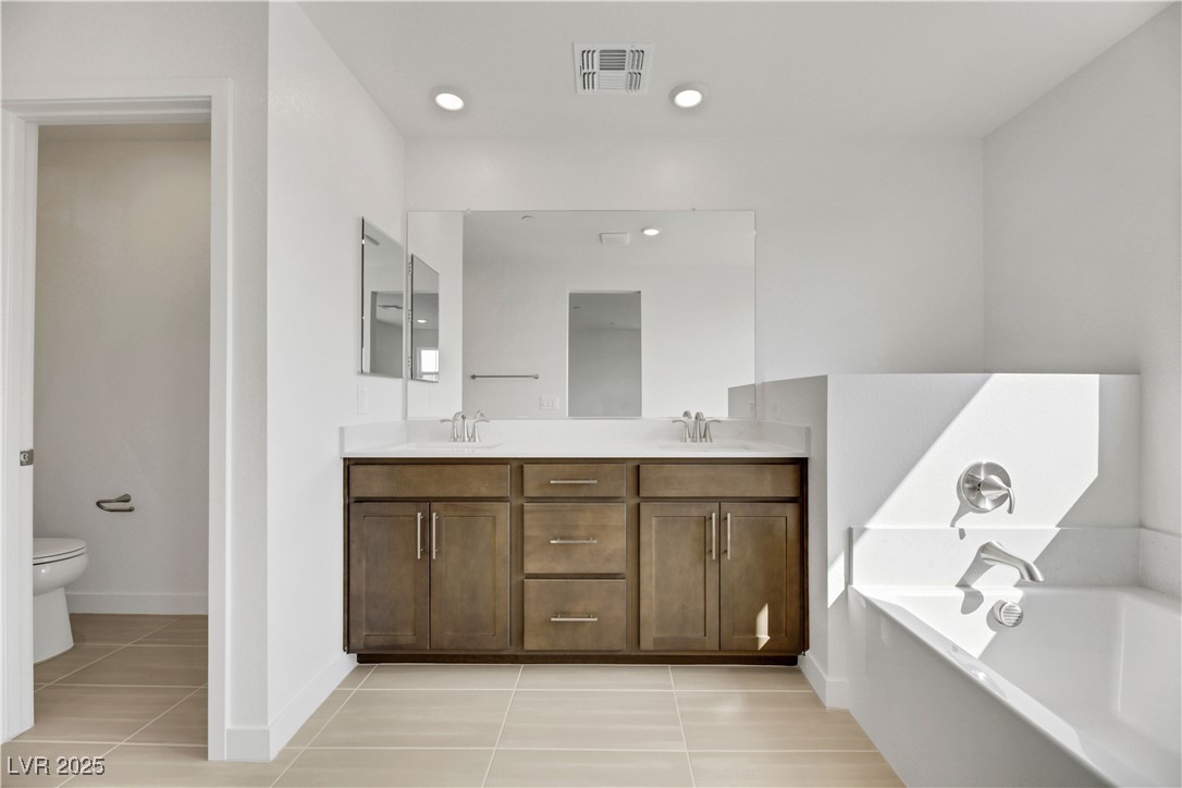 2770 Alfena Place Henderson, NV 89044 - Photo 22 of 26 Bathroom featuring light tile patterned flooring, double vanity, a garden tub, and recessed lighting