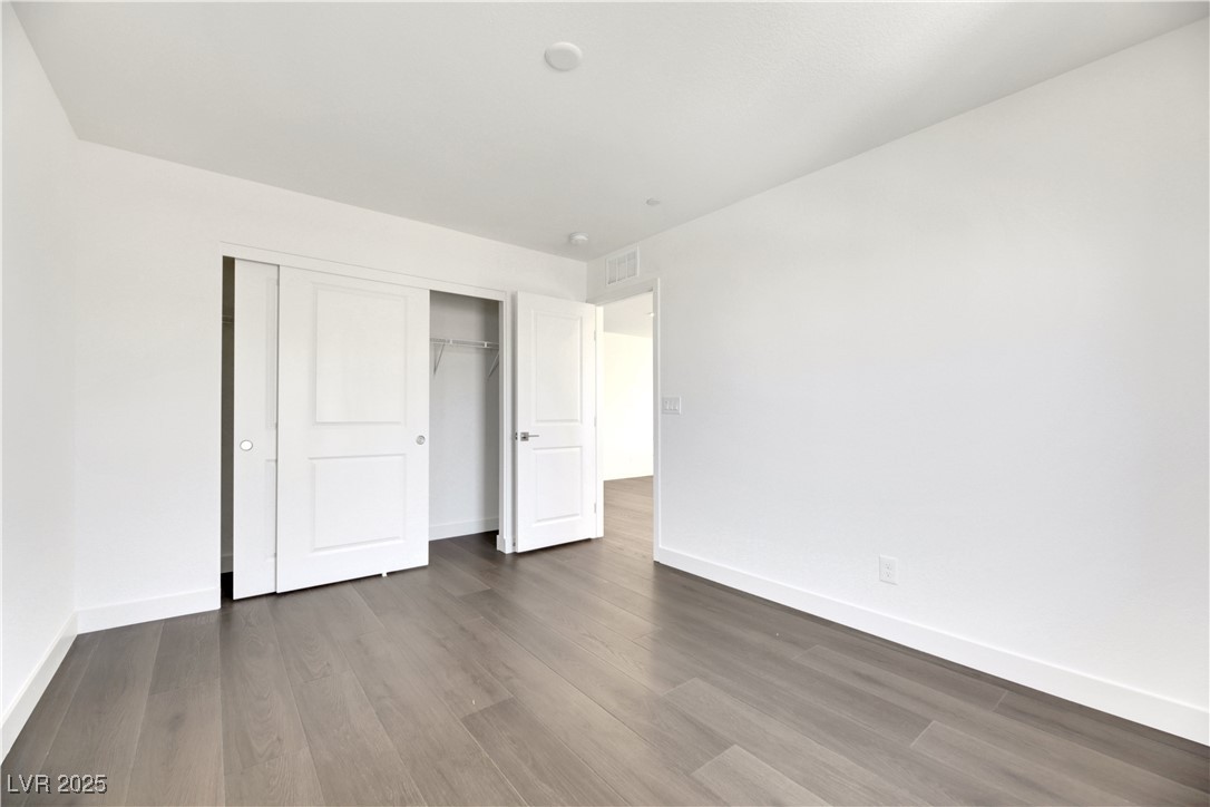 2770 Alfena Place Henderson, NV 89044 - Photo 3 of 26 Unfurnished bedroom featuring wood finished floors and a closet