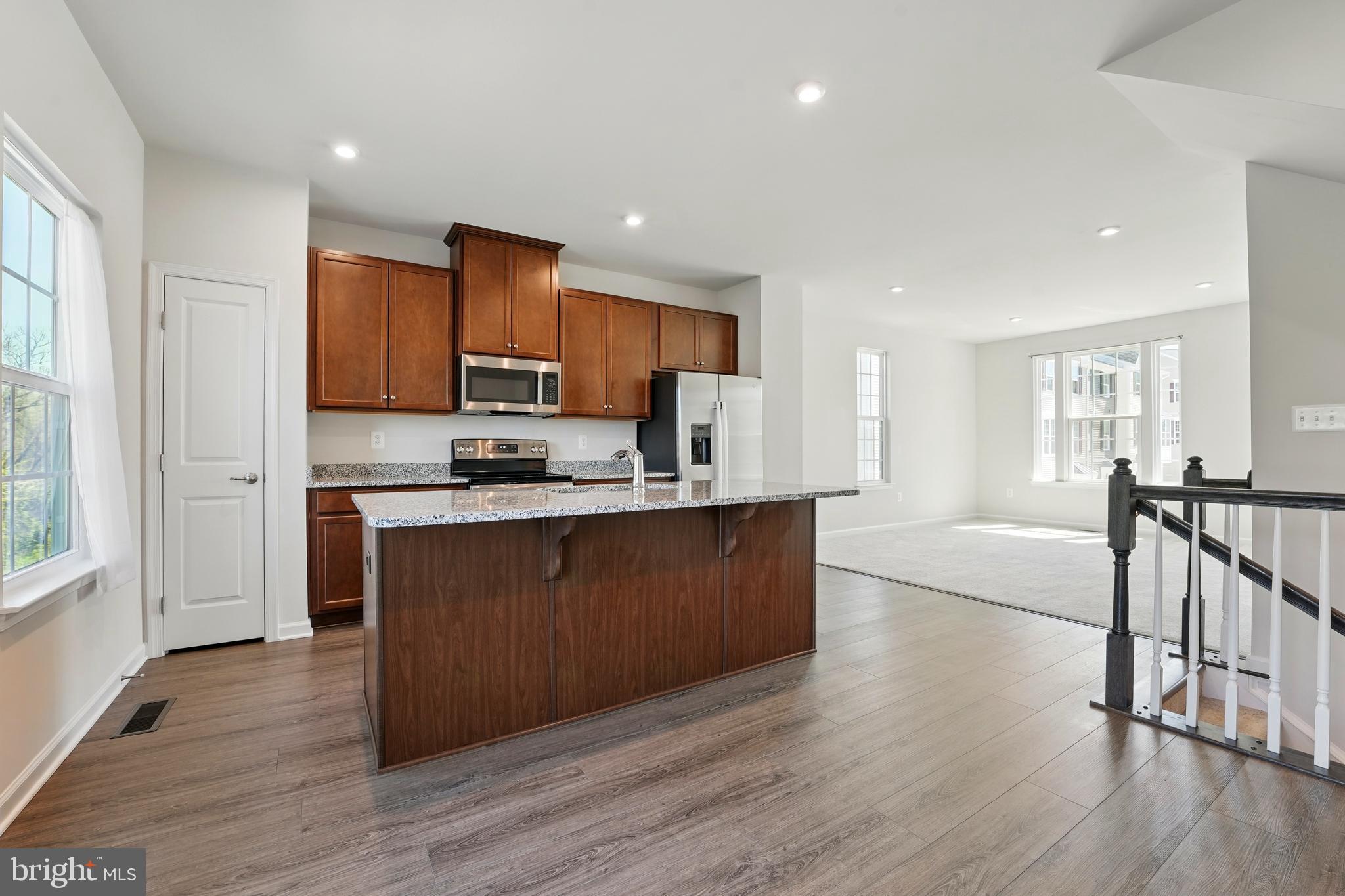 1754 Scenic Loop Culpeper, VA 22701 - Photo 4 of 39 a kitchen with stainless steel appliances granite countertop a refrigerator a stove top oven a sink and dishwasher with wooden floor