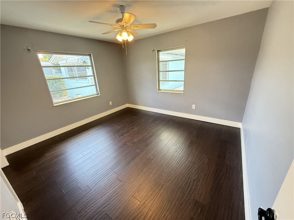 1534 Ricardo Avenue Fort Myers, FL 33901 - Photo 12 of 22 an empty room with wooden floor chandelier fan and windows